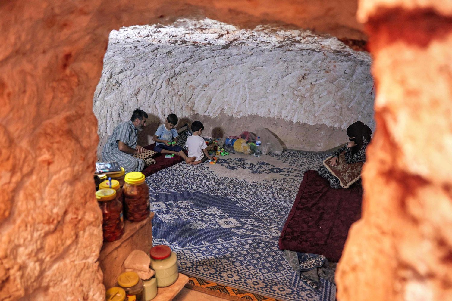 «القصف أفضل من المخيمات»… سوري يحفر ملجأ تحت الصخر ليحمي عائلته